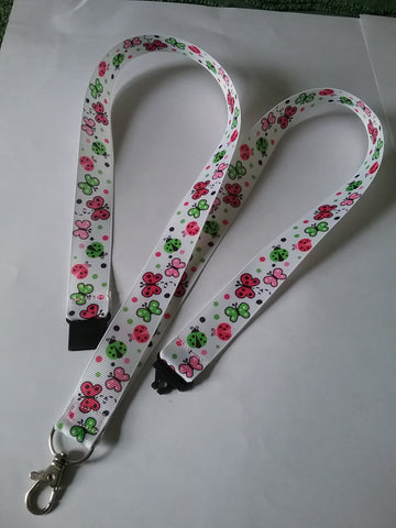 LANYARD white grosgrain ribbon with butterflies & ladybirds as the pattern with safety breakaway clip & silver colored swivel clasp id or whistle butterfly holder
